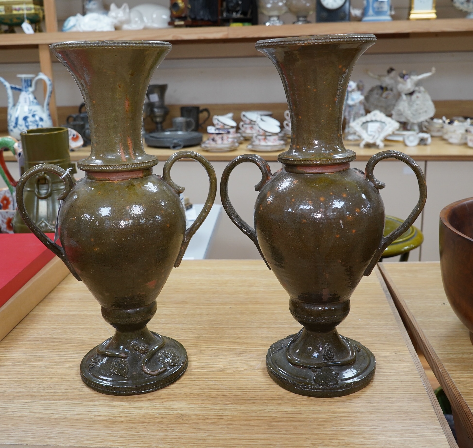 A pair of 19th century continental green glazed two handled pottery vases, 43cm high. Condition - fair